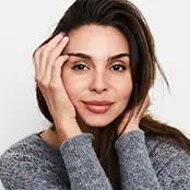 A close-up portrait of a woman with long dark hair, showcasing a smooth forehead and naturally elevated, symmetrical eyebrows that create an open and refreshed appearance around the eyes. - Brow lift in San Francisco, CA