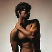 A dramatic, high-contrast side profile of a man’s upper torso and neck, showcasing a sharp, muscular jawline and a tight, contoured neck area. - Necklift in San Francisco, CA